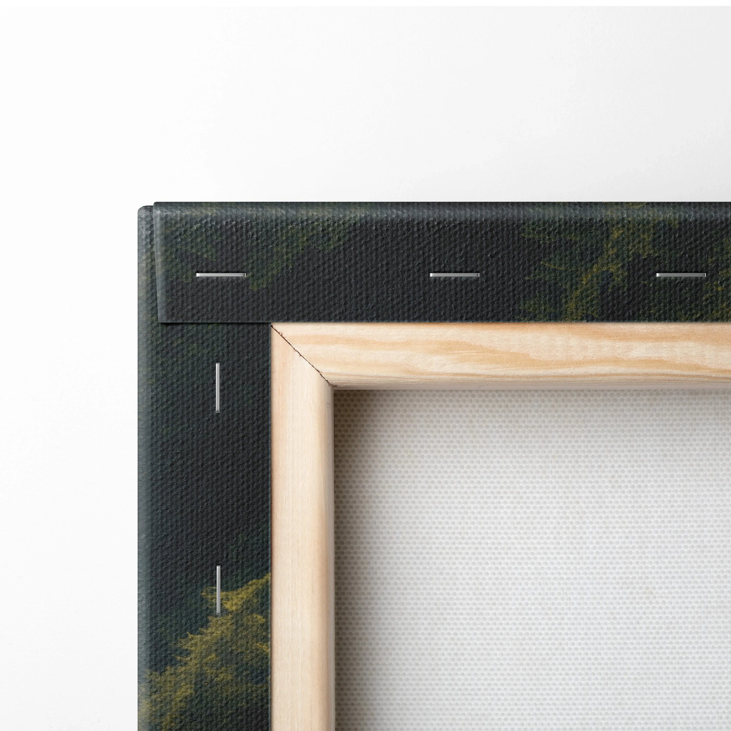 Close-up of a stretched canvas corner with natural wood frame and black printed waterfall design on fabric wall art.