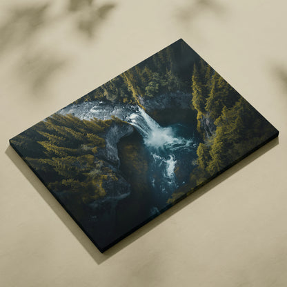 Canvas wall art featuring a dark, moody aerial view of a waterfall surrounded by dense green forest.