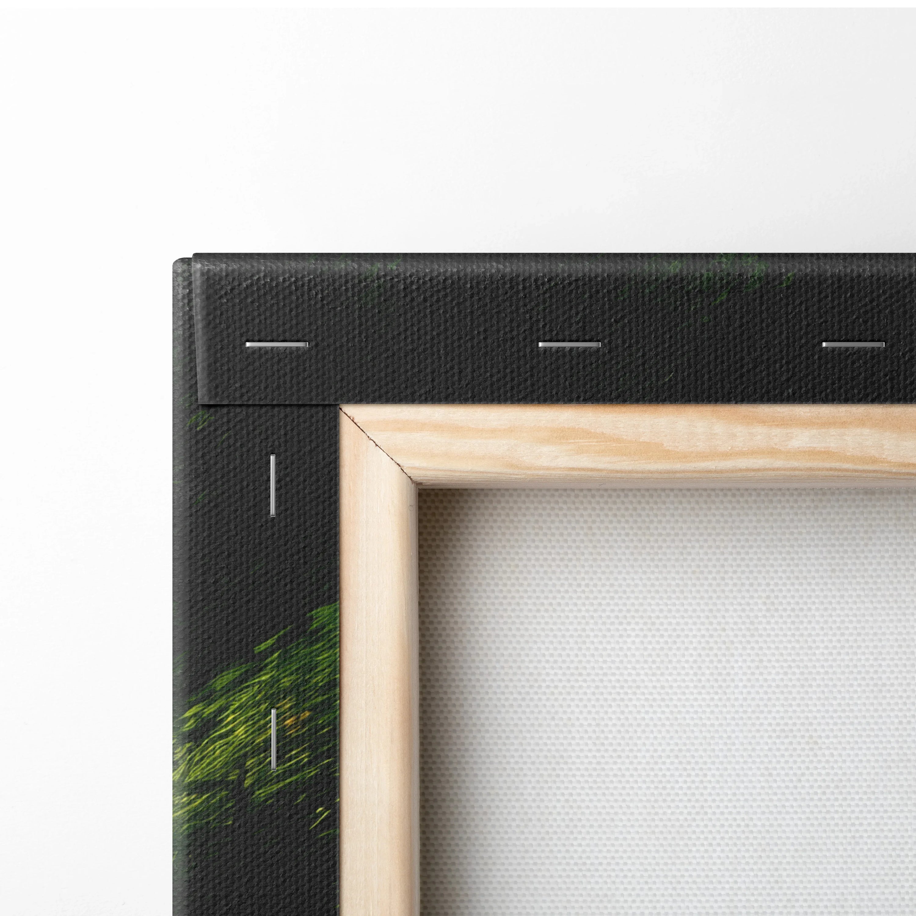 Close-up of corner of premium canvas wall art with black folded edge and natural wood stretcher frame showing texture and.