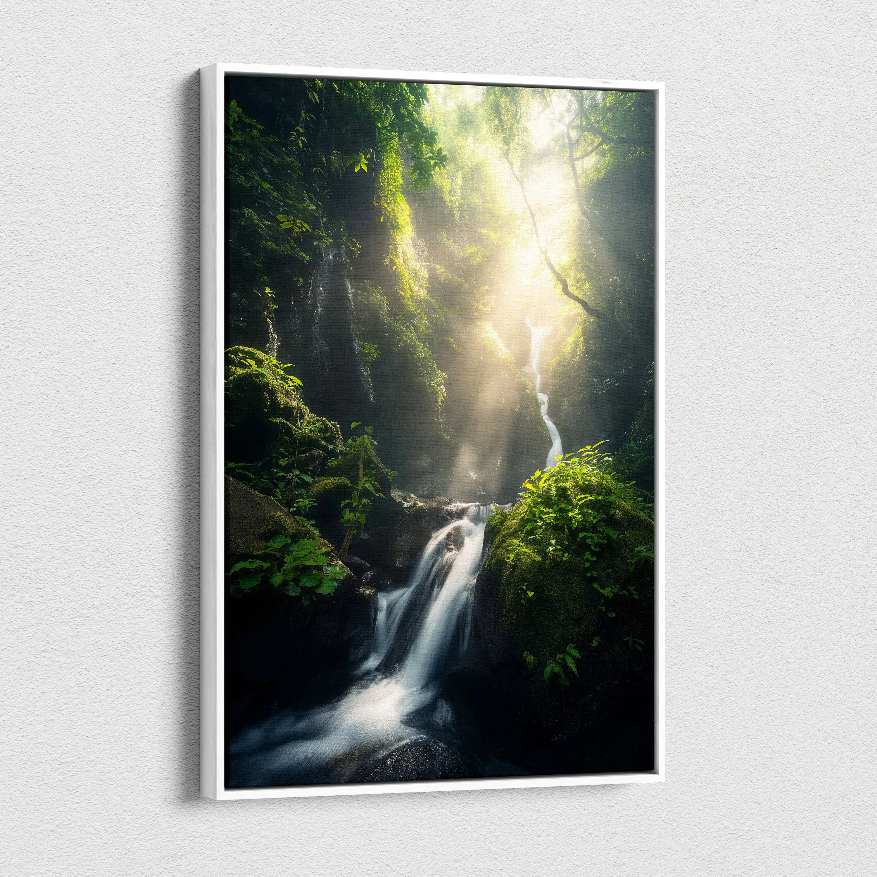 Vertical canvas wall art depicting a lush green forest with a cascading waterfall and sunlight streaming through dense.