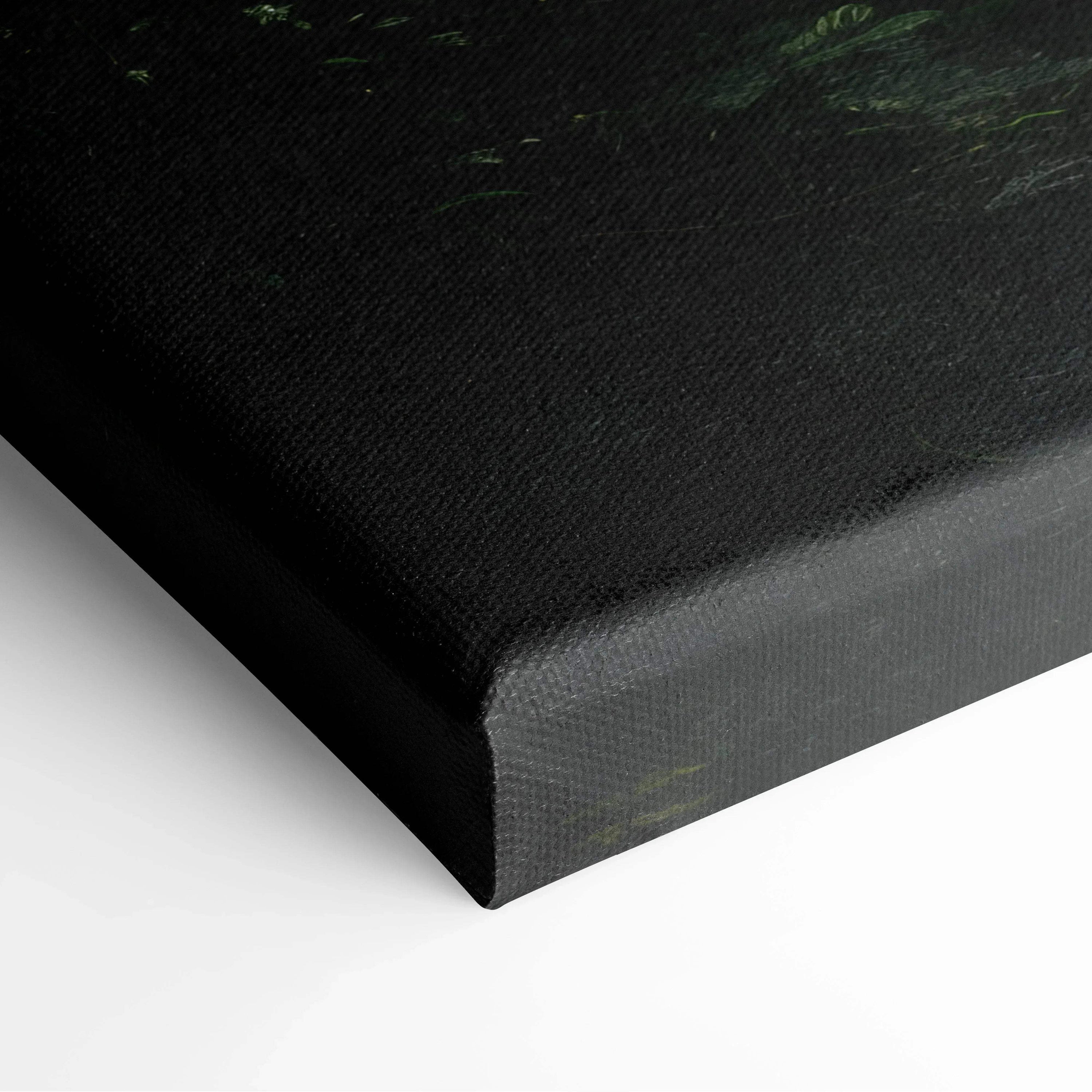 Close-up of black-wrapped edge of high-resolution canvas wall art with dark forest and waterfall design.