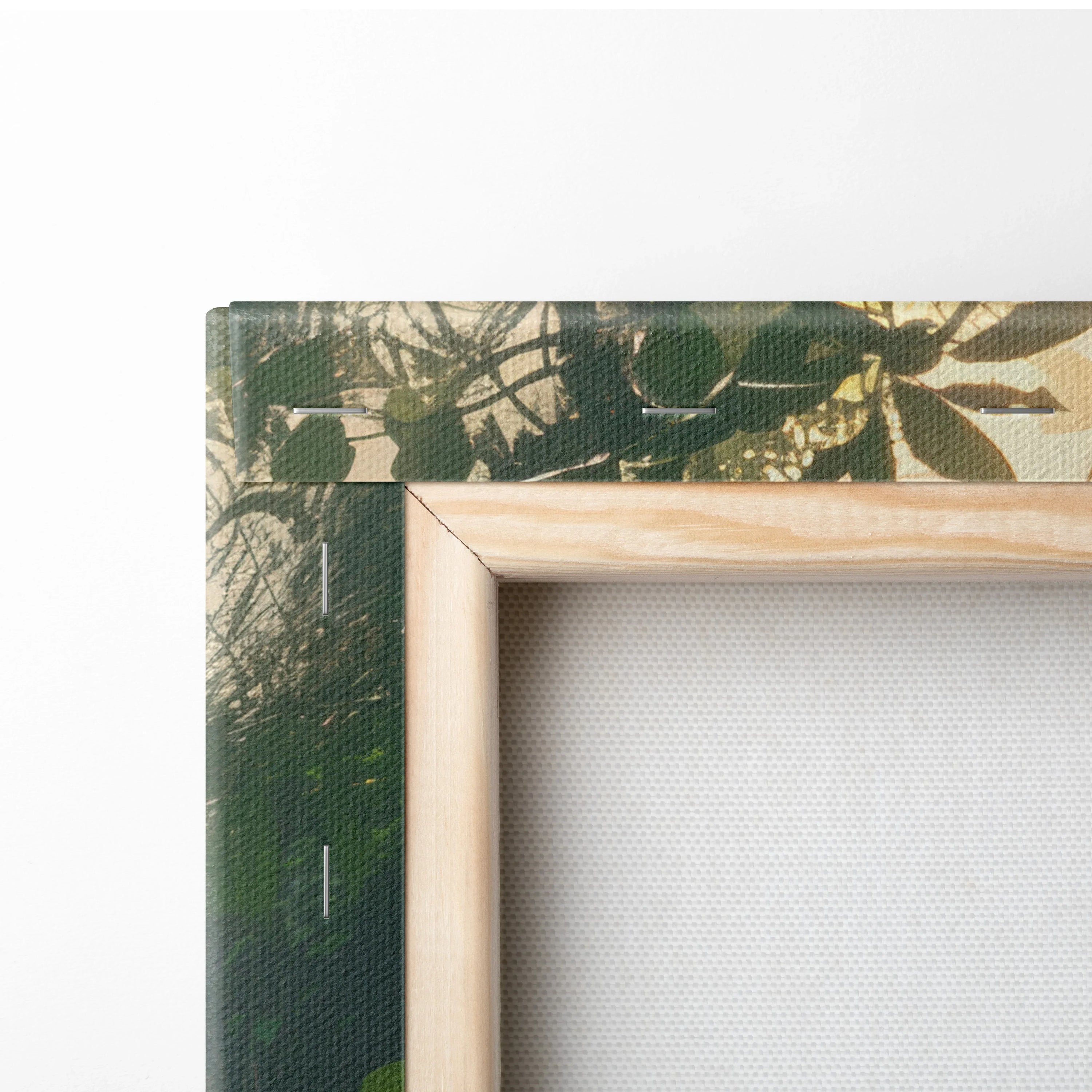 Close-up of wooden-framed canvas wall art with tropical forest and waterfall print, textured surface.