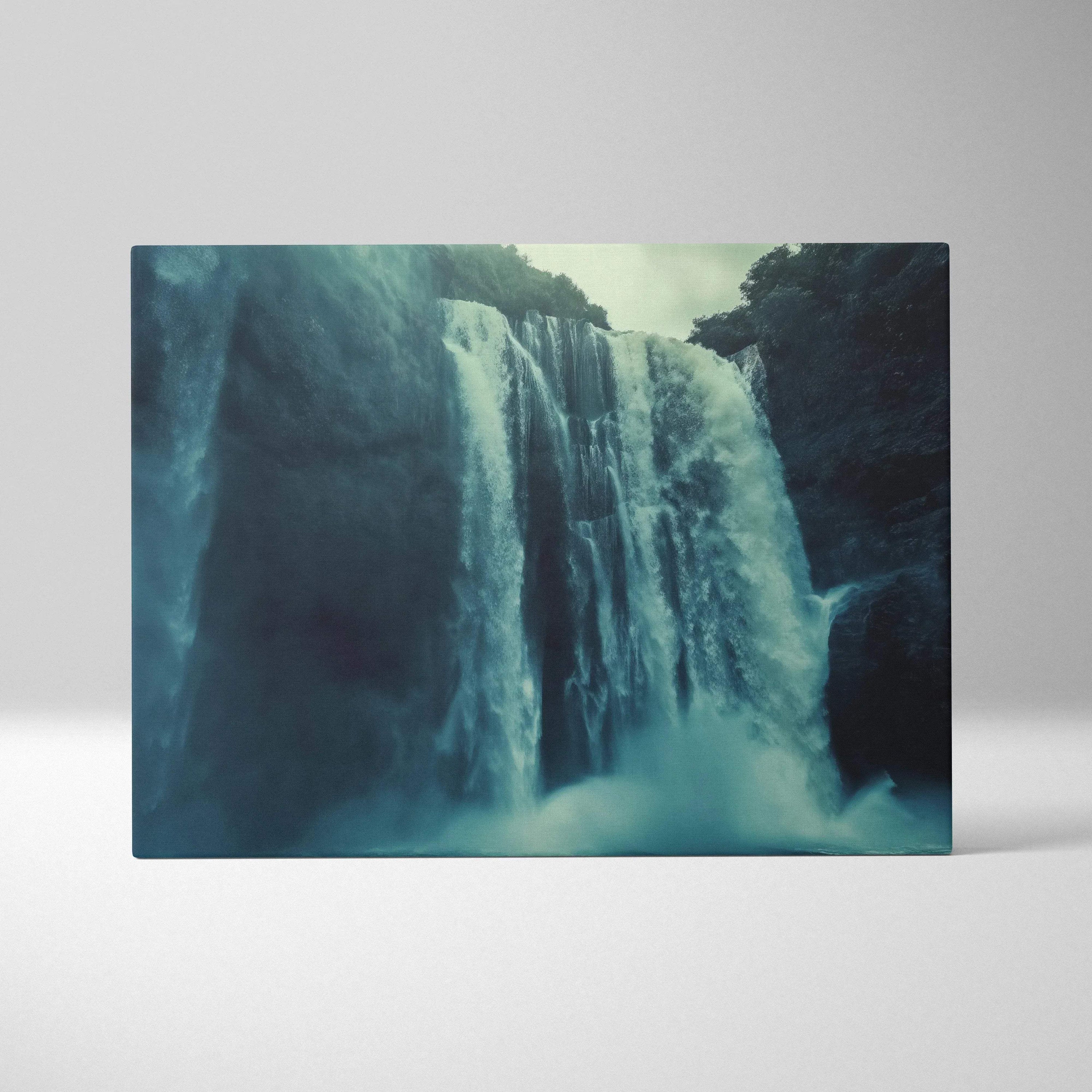 Canvas wall art of a misty waterfall cascading over dark rock cliffs with lush greenery above.