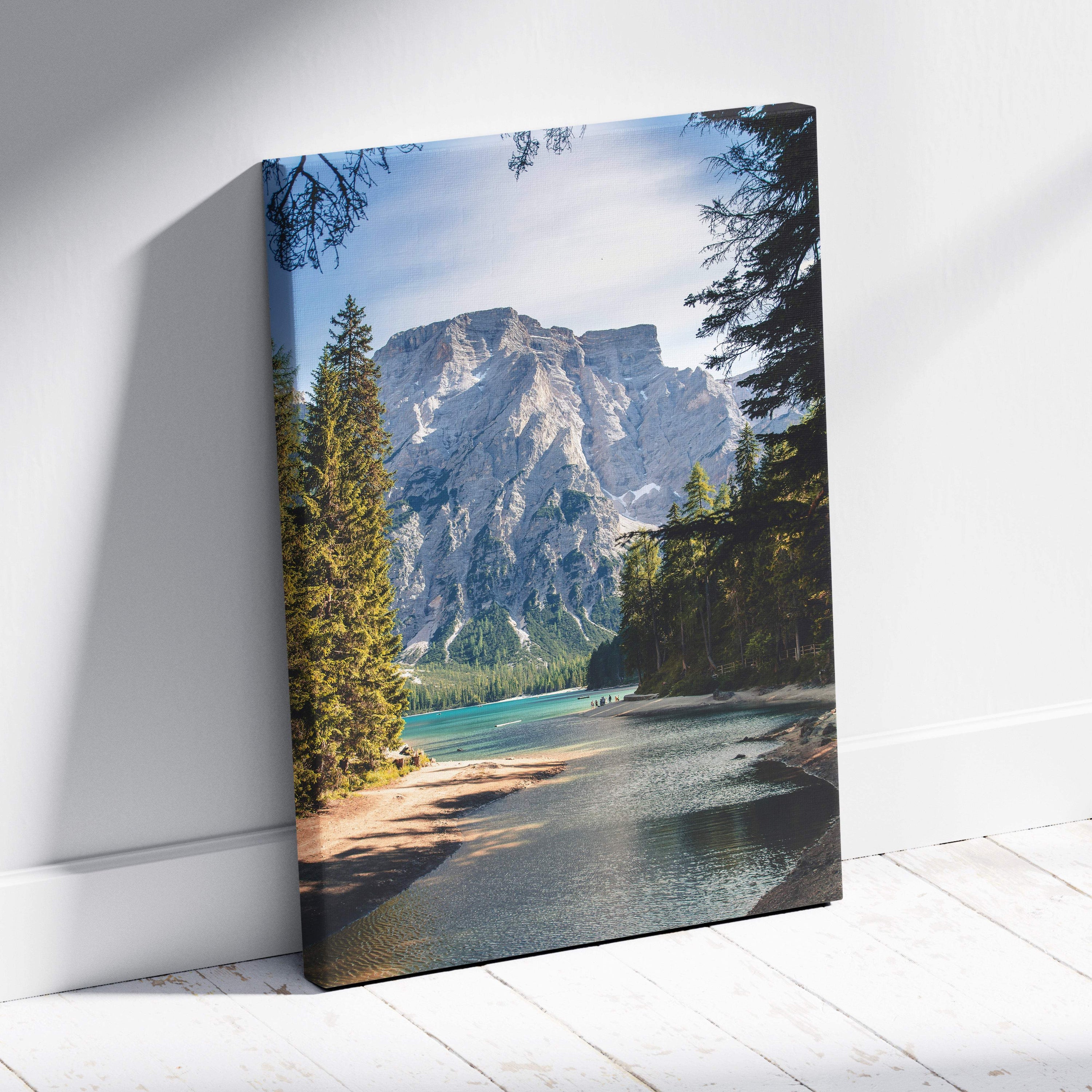 A framed canvas print of a green blue mountain lake with evergreen trees and rugged peaks for serene nature decor