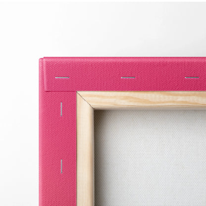 Close-up of pink canvas edge with natural wood frame corner and visible staples on wall art backing.