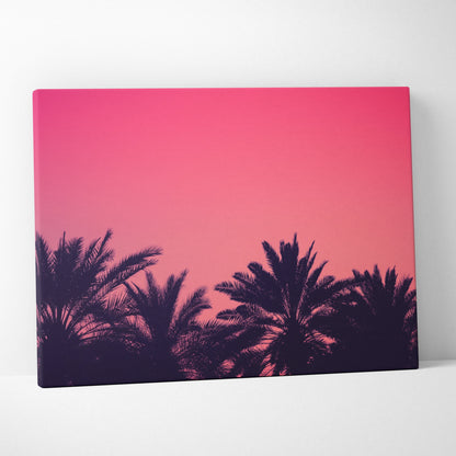 Canvas wall art featuring black palm trees silhouetted against a vibrant pink and purple sunset sky.