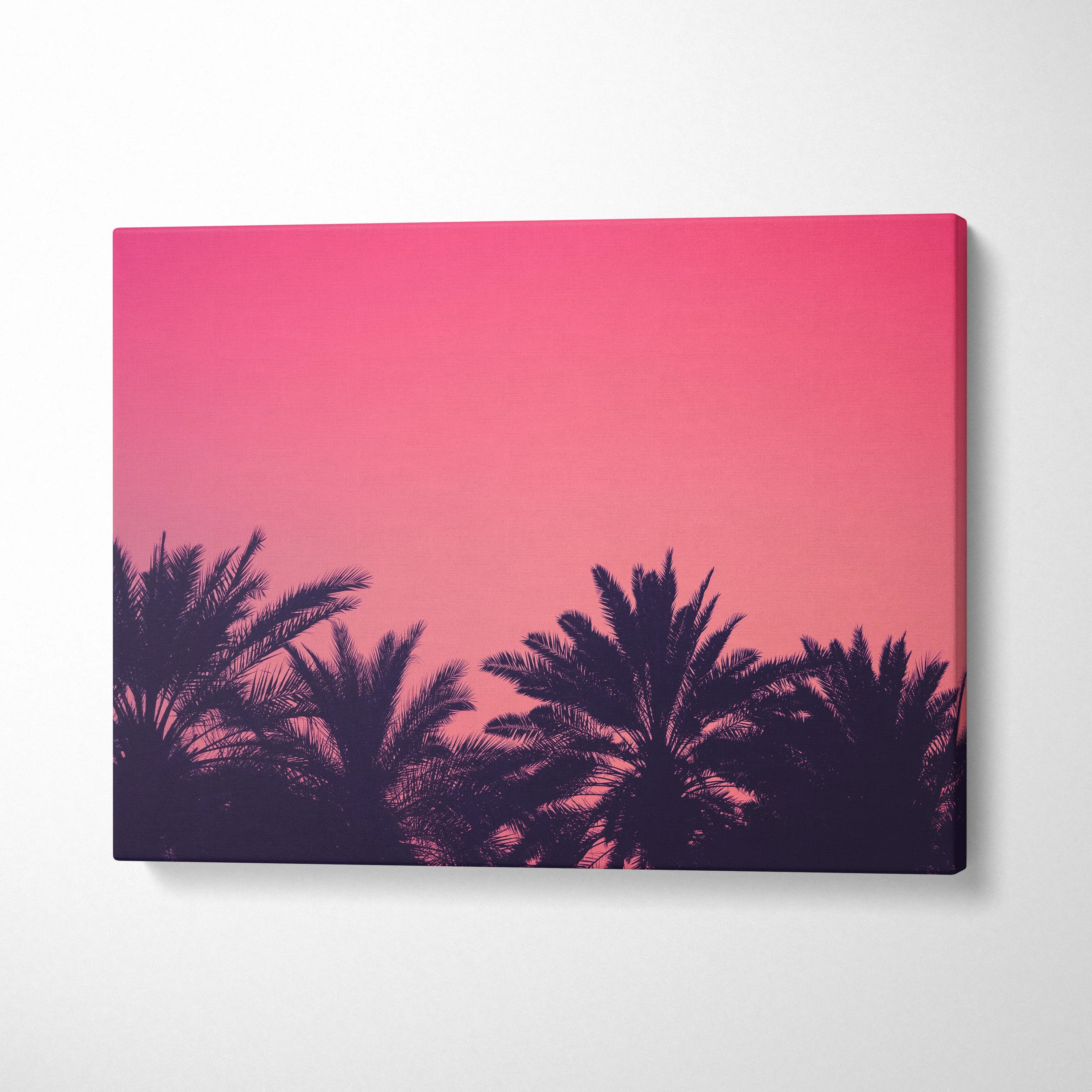 Canvas wall art featuring dark palm trees silhouetted against a vibrant pink and orange sunset sky.