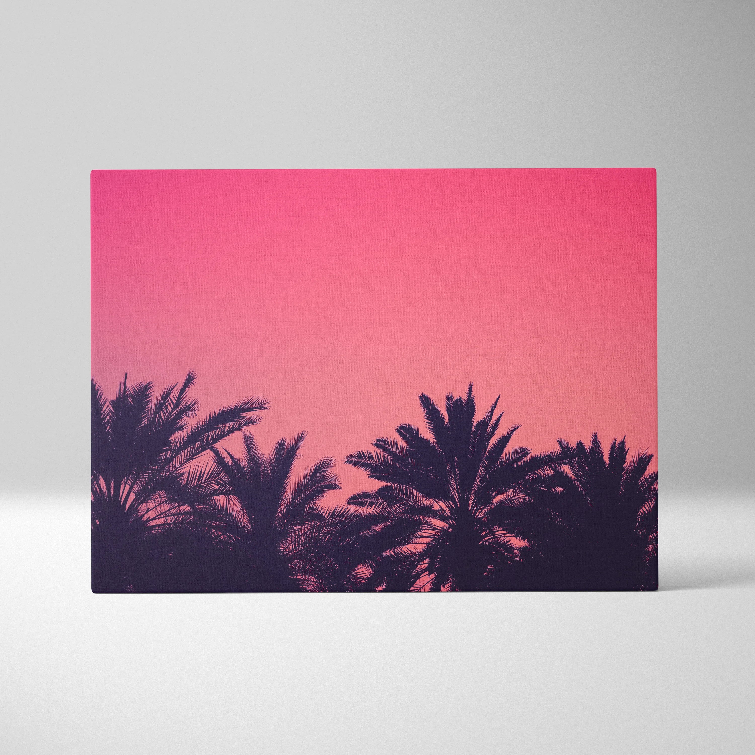 Canvas wall art featuring dark palm silhouettes against a vivid pink sunset sky.