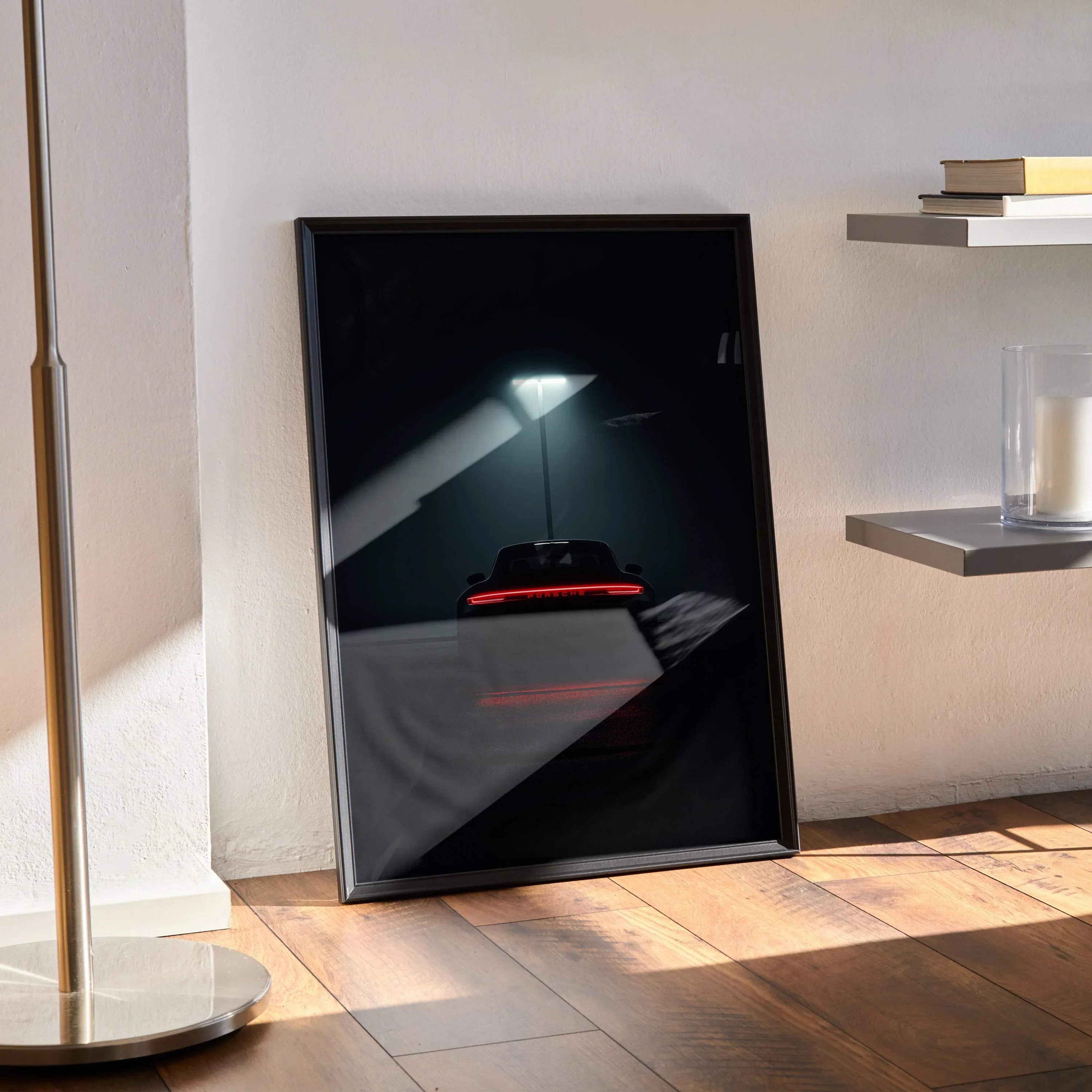 Vintage Porsche 911 Turbo sports car wall art poster in a black frame leaning against a light wall on a wooden floor.