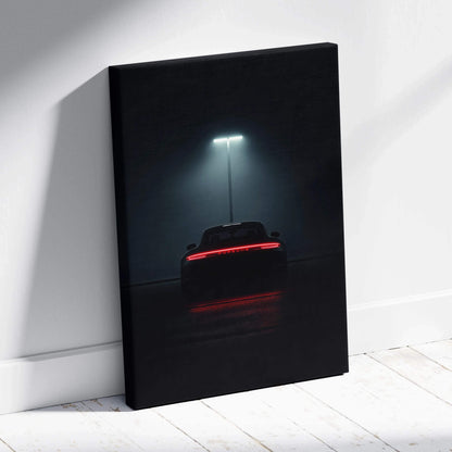 Dark canvas wall art featuring a rear view of a Porsche sports car illuminated by a single streetlight.