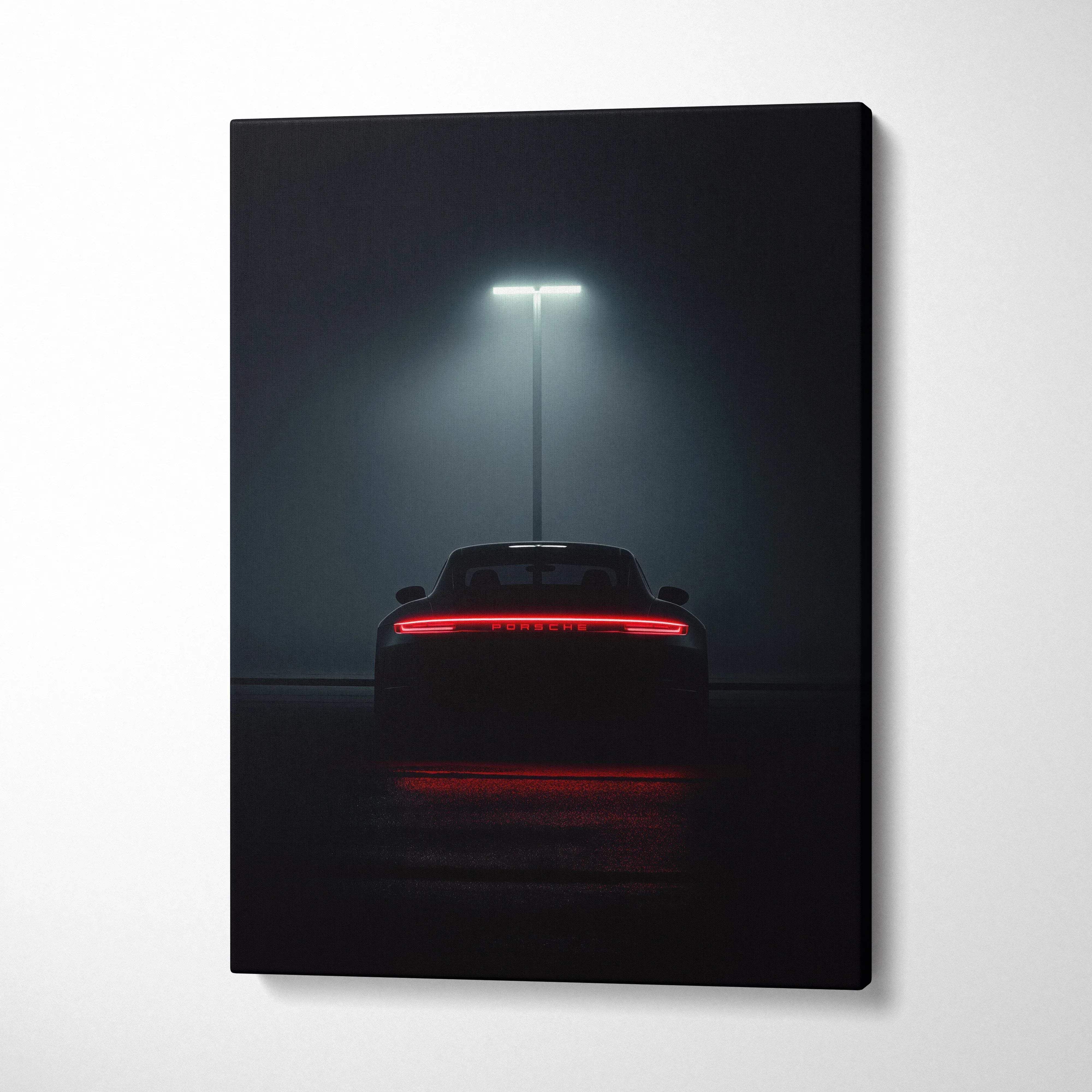Dark canvas wall art featuring rear view of a Porsche sports car illuminated under a single overhead light.