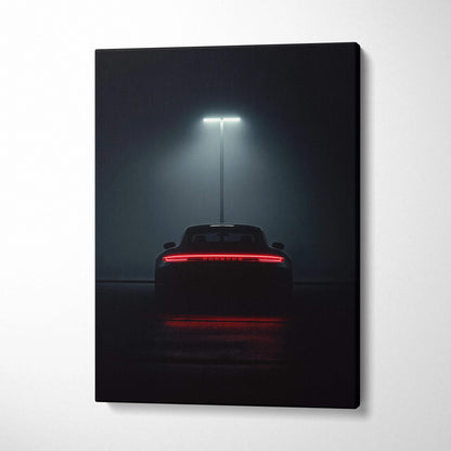 Dark canvas wall art featuring rear view of a Porsche sports car illuminated under a single overhead light.