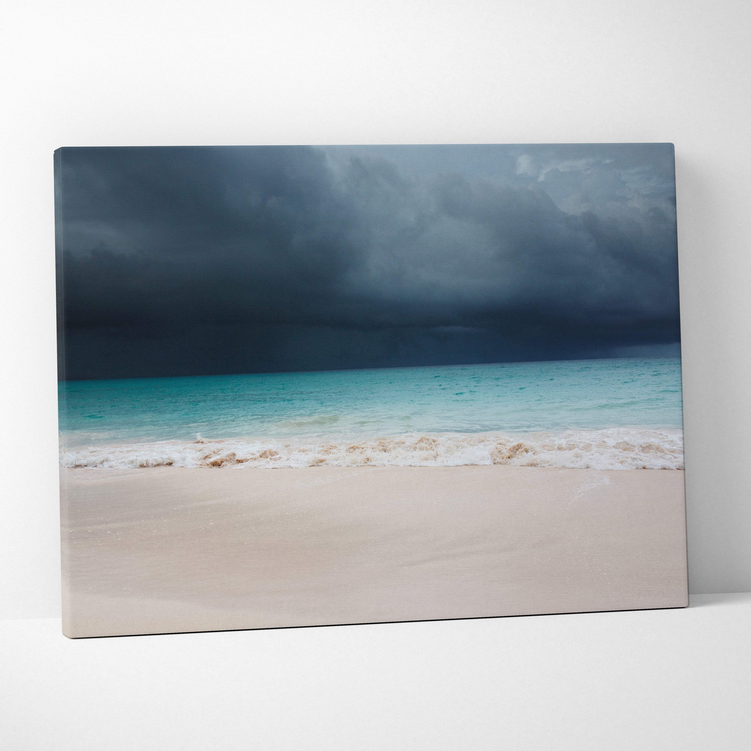 A rectangular canvas print of a stormy beach with turquoise waves dark thunderclouds and pale sand wall decor
