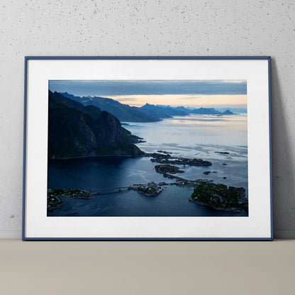 Mountain sunset landscape poster with blue and orange sky, coastal cliffs, and calm water wall art.