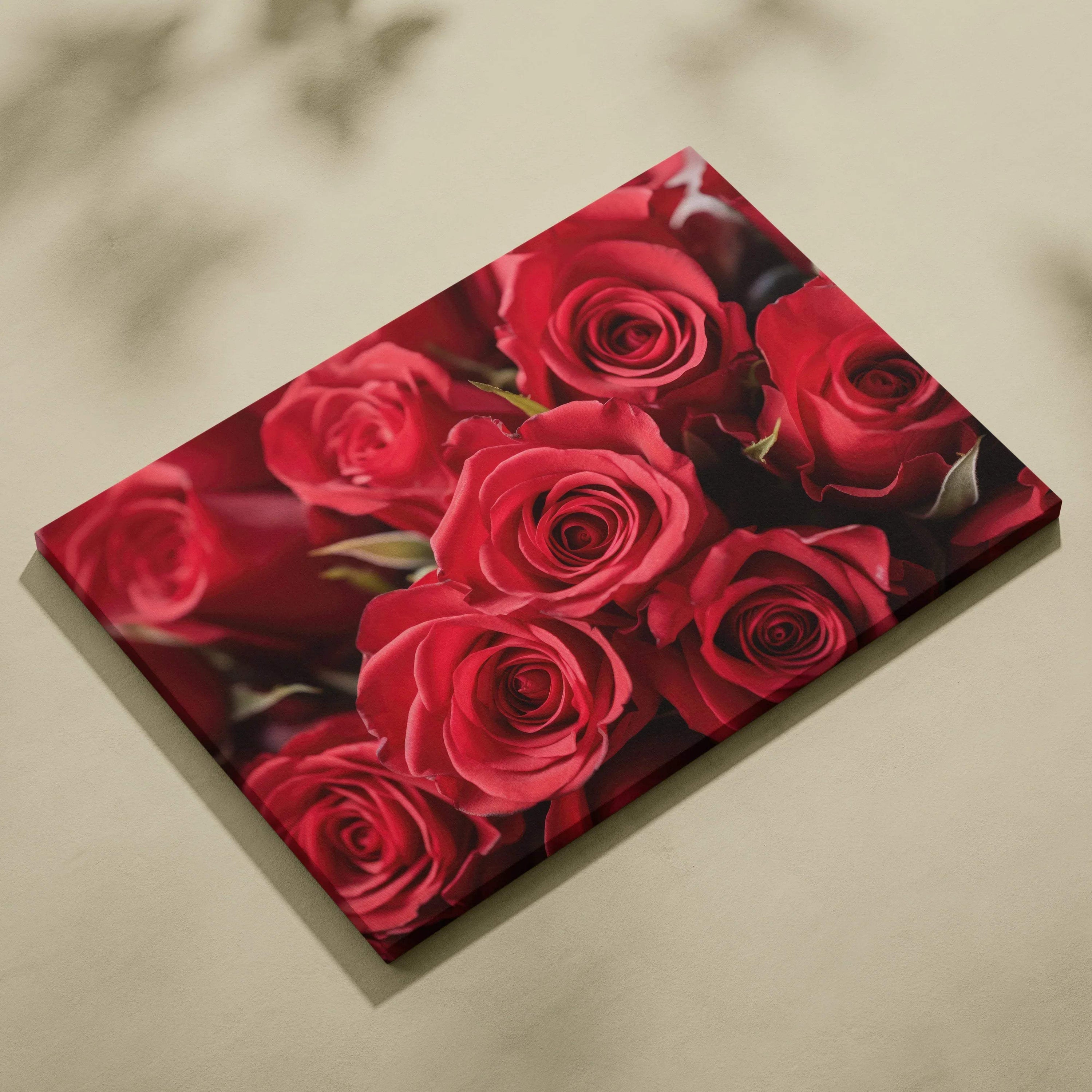 Canvas wall art featuring vibrant red roses with detailed petals and deep green leaves on a black background.