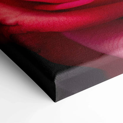 Close-up of vibrant red and pink rose petals on textured canvas wall art with wrapped edges.