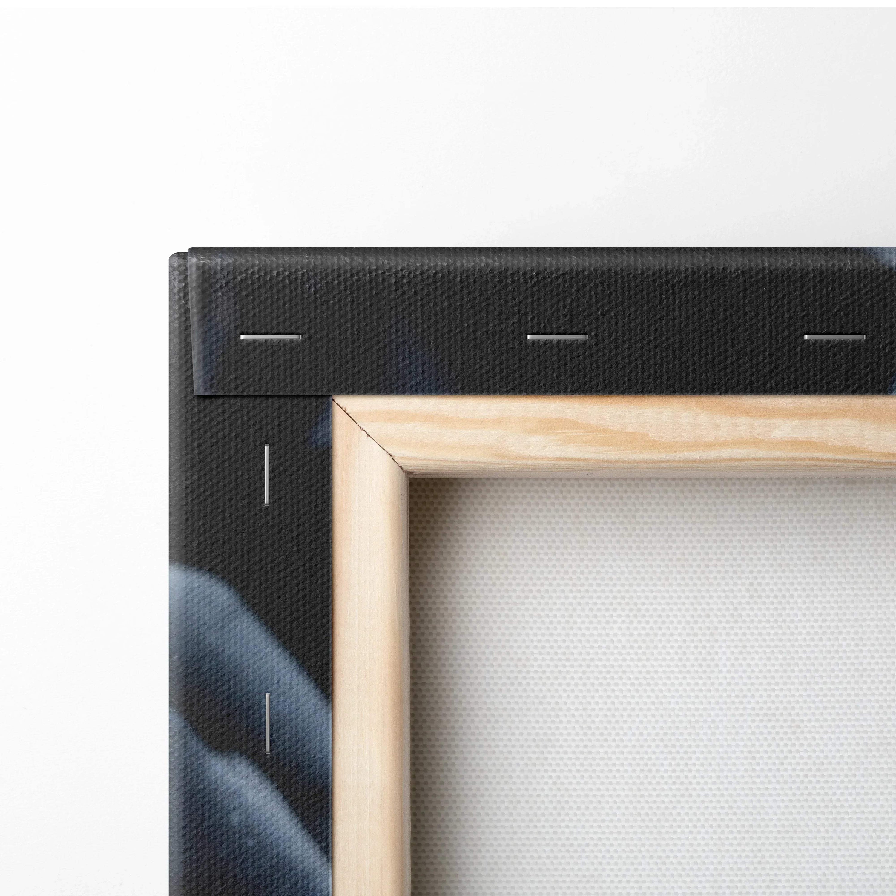 Close-up of black-stapled canvas edge with natural wood frame and white stretched fabric back.