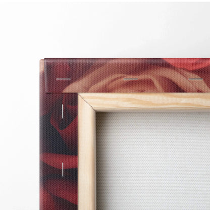 Close-up of wooden stretcher frame with vibrant red and pink rose canvas print wrapped and stapled around edges.