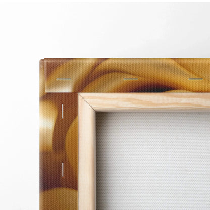 Close-up of wooden frame with yellow gold floral canvas wrapped and stapled at the back of wall art.