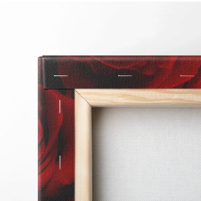 Close-up of stretched canvas wall art with vibrant red rose floral print and natural wooden frame edges.