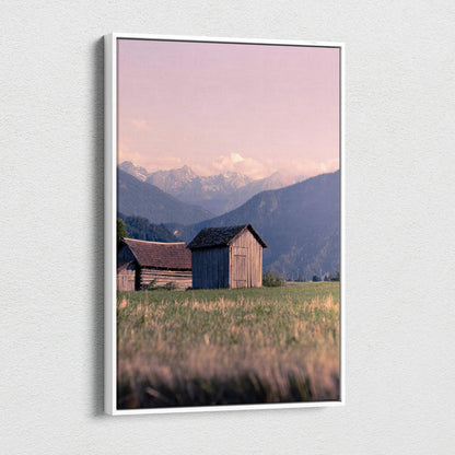 Canvas wall art featuring wooden buildings with mountains and a pink sunset sky.