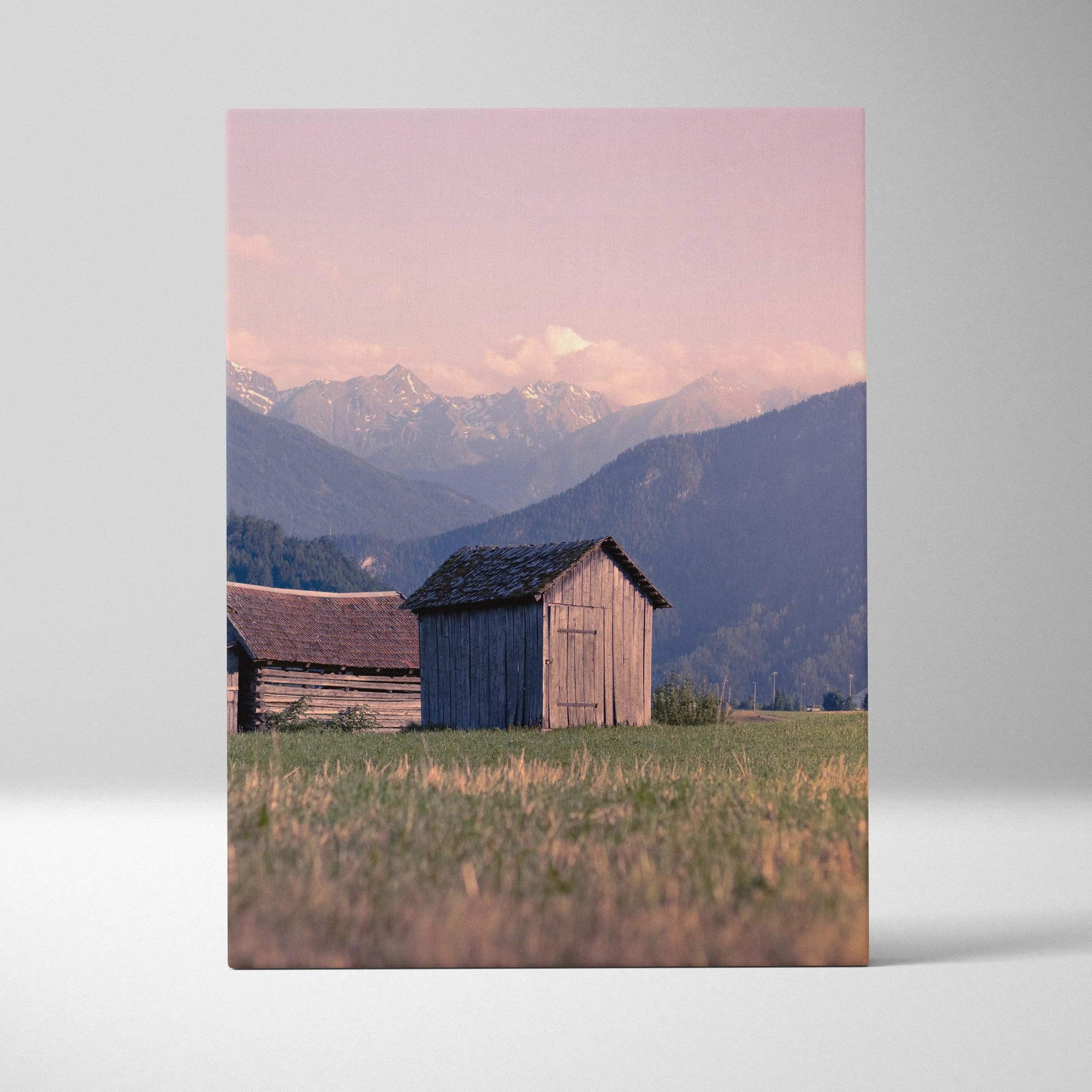 Canvas wall art featuring golden sunset over mountains with rustic wooden buildings.
