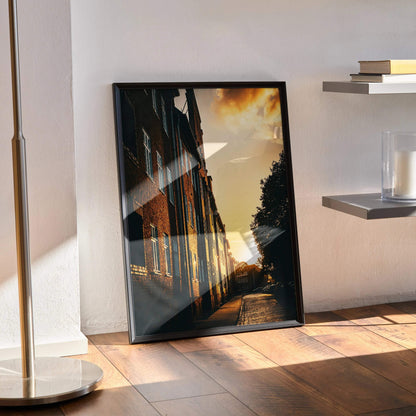 Vibrant sunset cityscape poster with silhouette buildings and warm orange sky wall art.