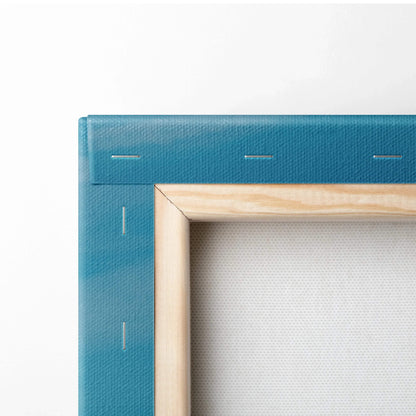 Close-up of blue canvas wrapped over wooden frame for wall art with visible staples and texture.