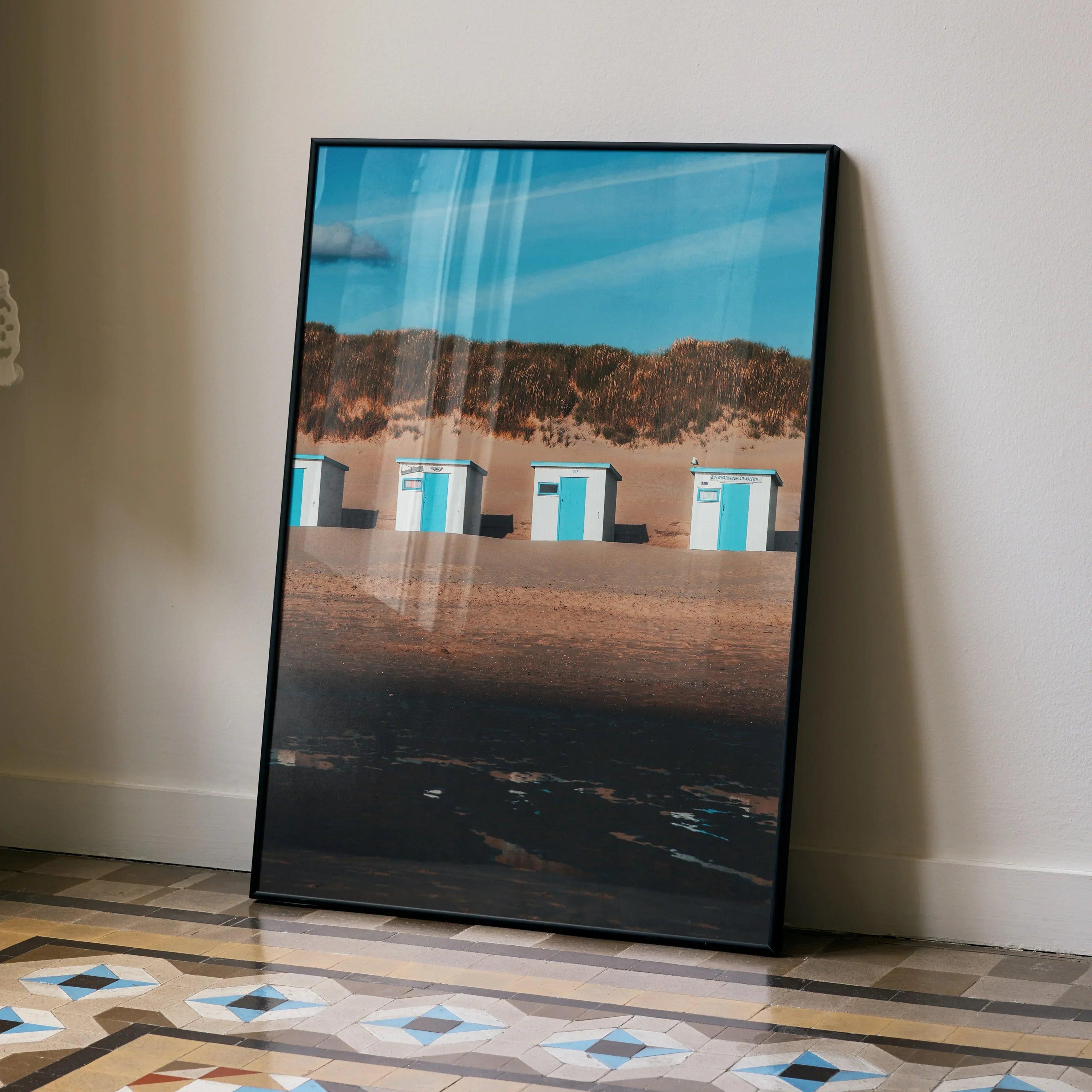 Serene beach landscape wall art poster with blue sky, sandy shore, and small beach huts in vertical format.