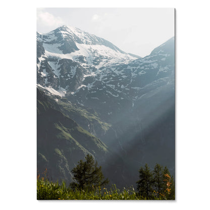 Vertical wall art poster of snow-capped mountains with sunlight rays over green forest.