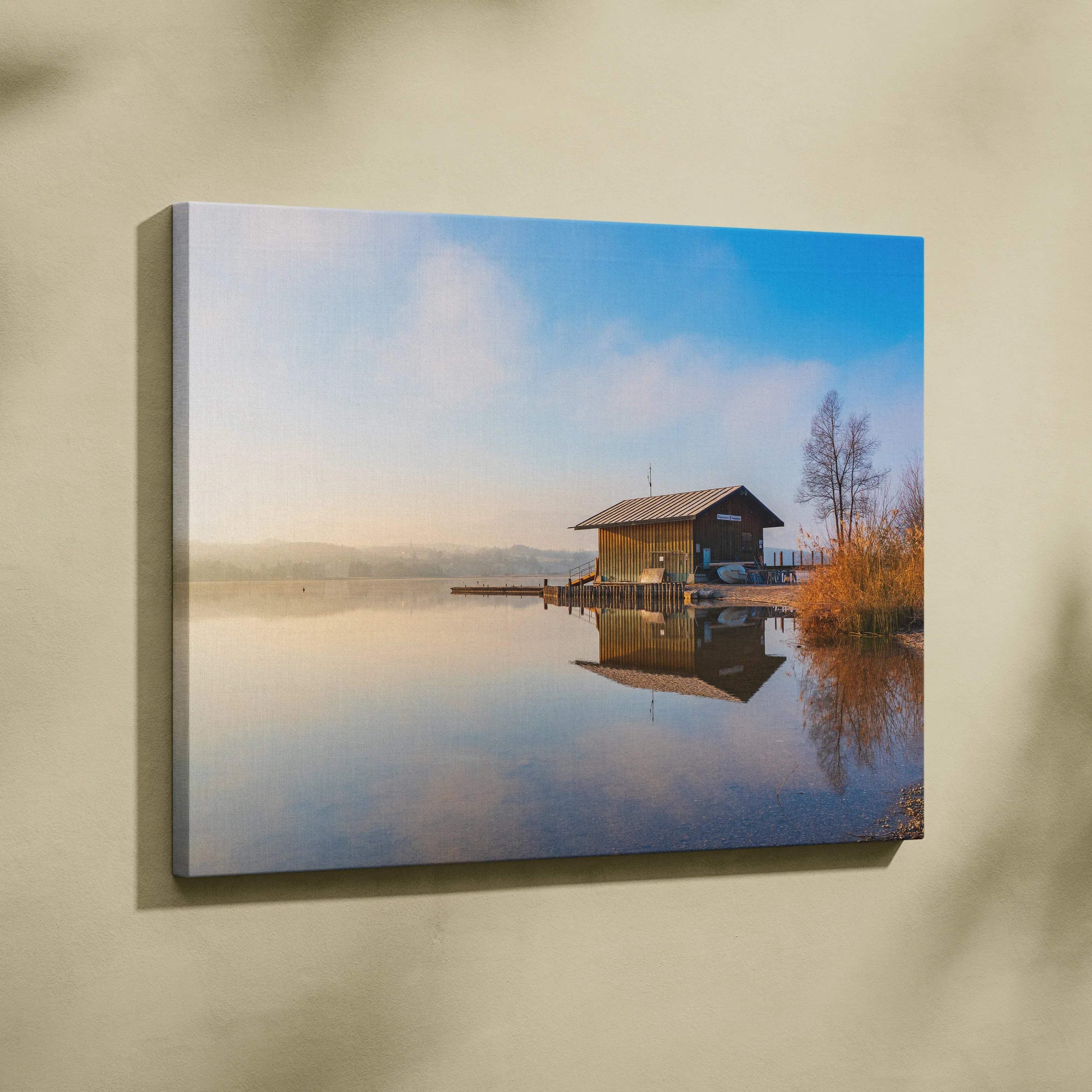 Tranquil nature and wooden house reflected on calm water canvas wall art in soft morning light.
