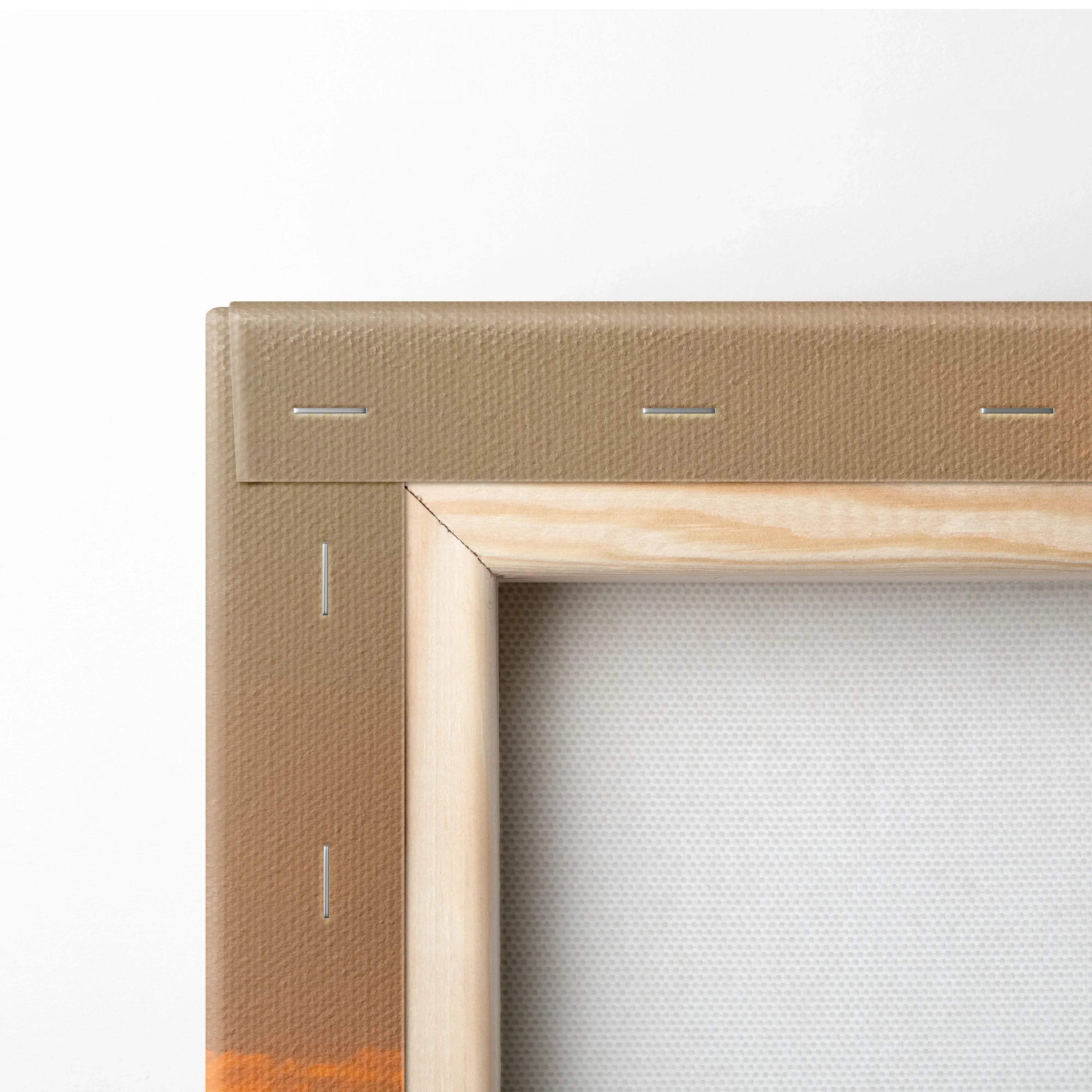 Close-up of beige canvas stretched over wooden frame with visible staples for wall art.
