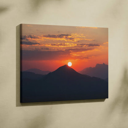 Sunset over mountain silhouette with vibrant orange sky on canvas wall art print.