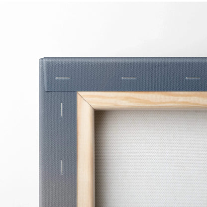 Close-up of wooden stretcher bars and textured grey canvas edge on wall art print.