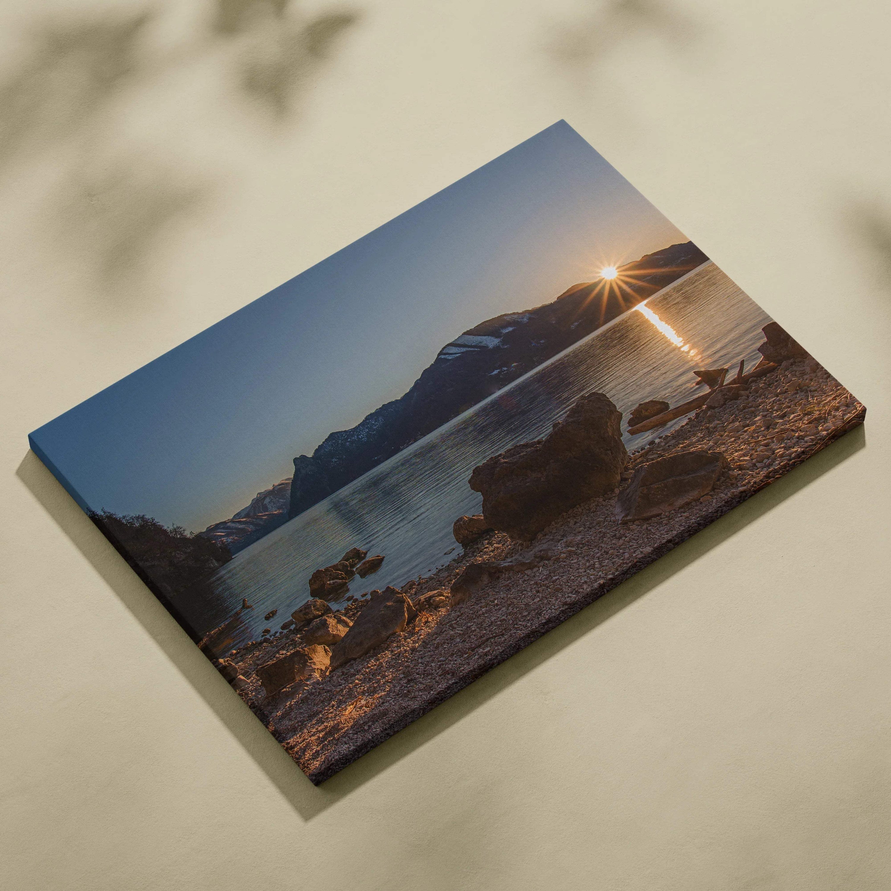 Canvas wall art featuring a mountain sunset over a calm lake with rocky shoreline.
