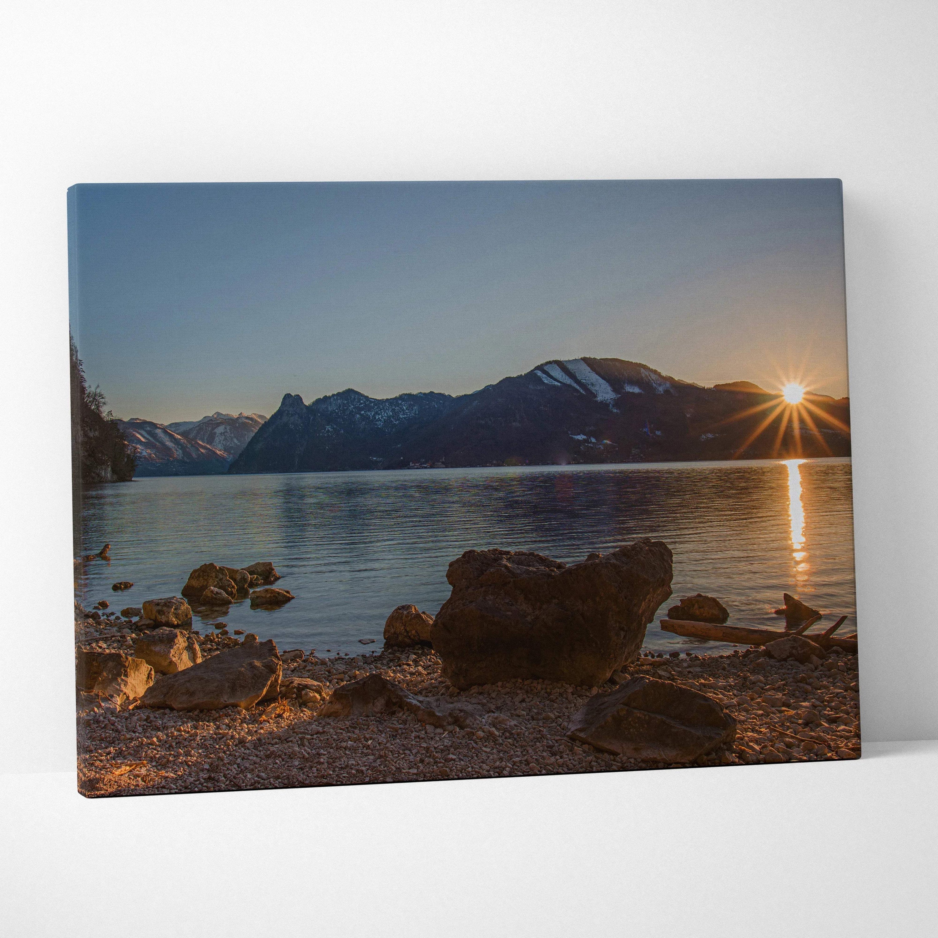 Mountain sunset reflected on calm lake with rocky shore, canvas wall art print.