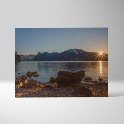 Mountain sunset reflecting on calm lake with rocky shoreline canvas wall art.