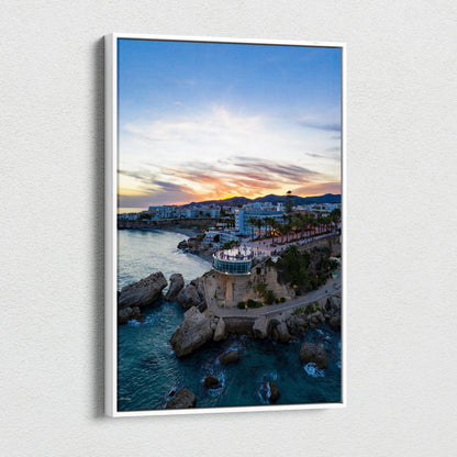 Canvas wall art featuring vibrant city skyline at sunset over rocky coastline and water.