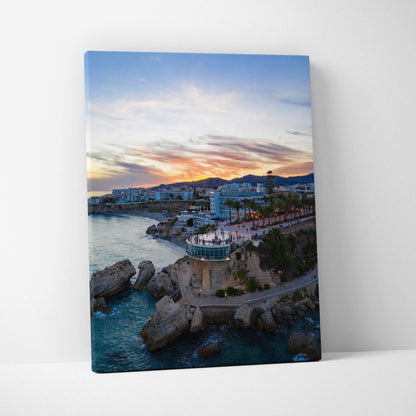 Canvas wall art featuring a vibrant city skyline at sunset with buildings and rocky coastline.