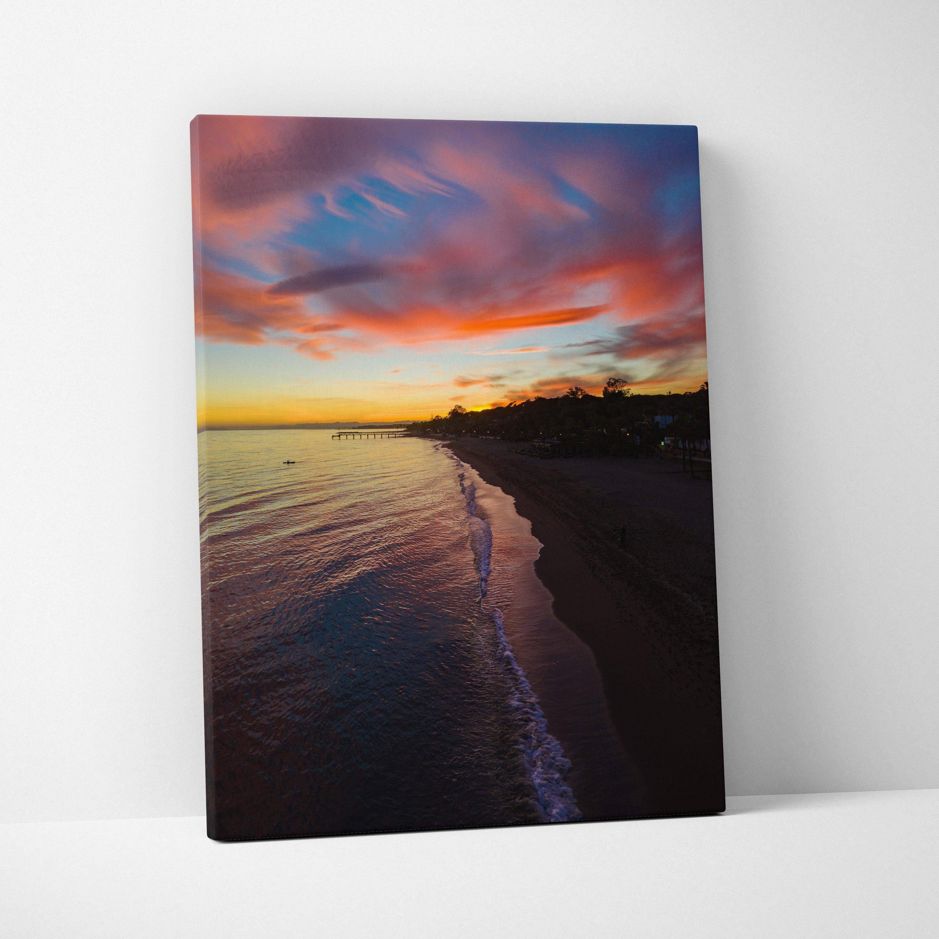 Vibrant beach sunset over calm ocean with colorful sky on vertical canvas wall art.