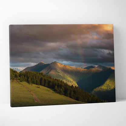 Mountain sunset canvas wall art with glowing peaks and dramatic cloud sky in warm tones.