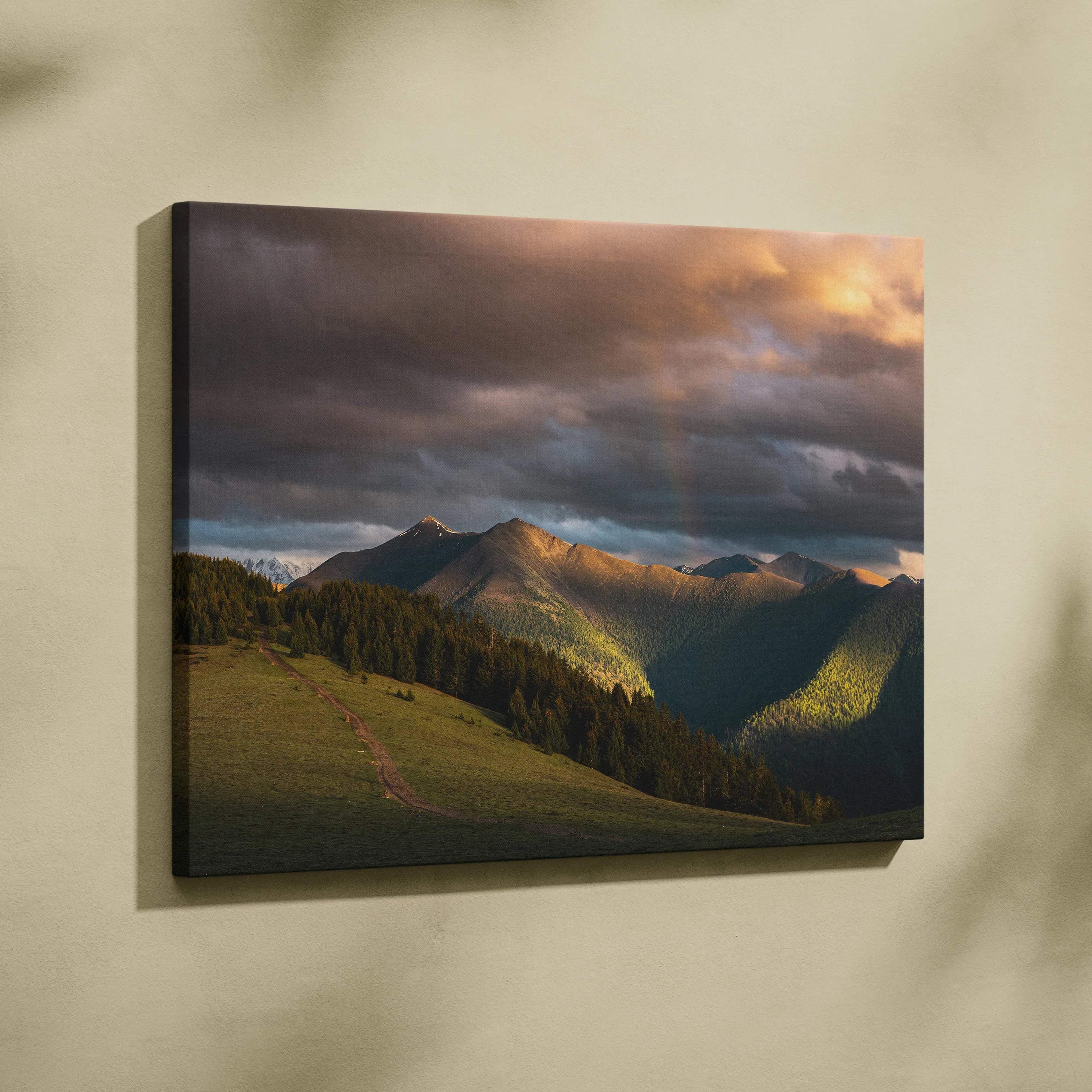 Canvas wall art featuring a mountain landscape at sunset with dramatic clouds and warm light.