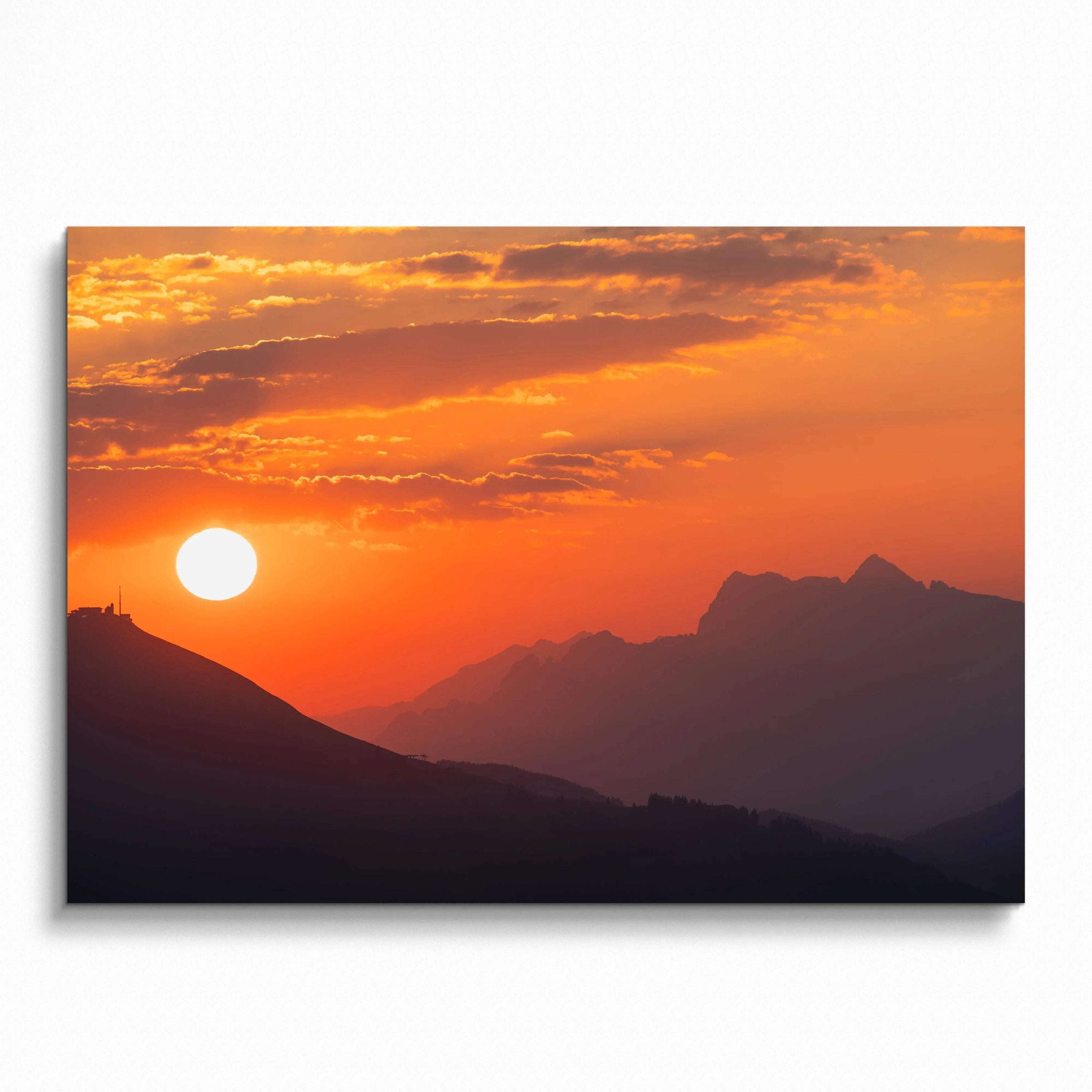 Sunset over layered mountain silhouettes in warm orange and purple tones wall art poster.