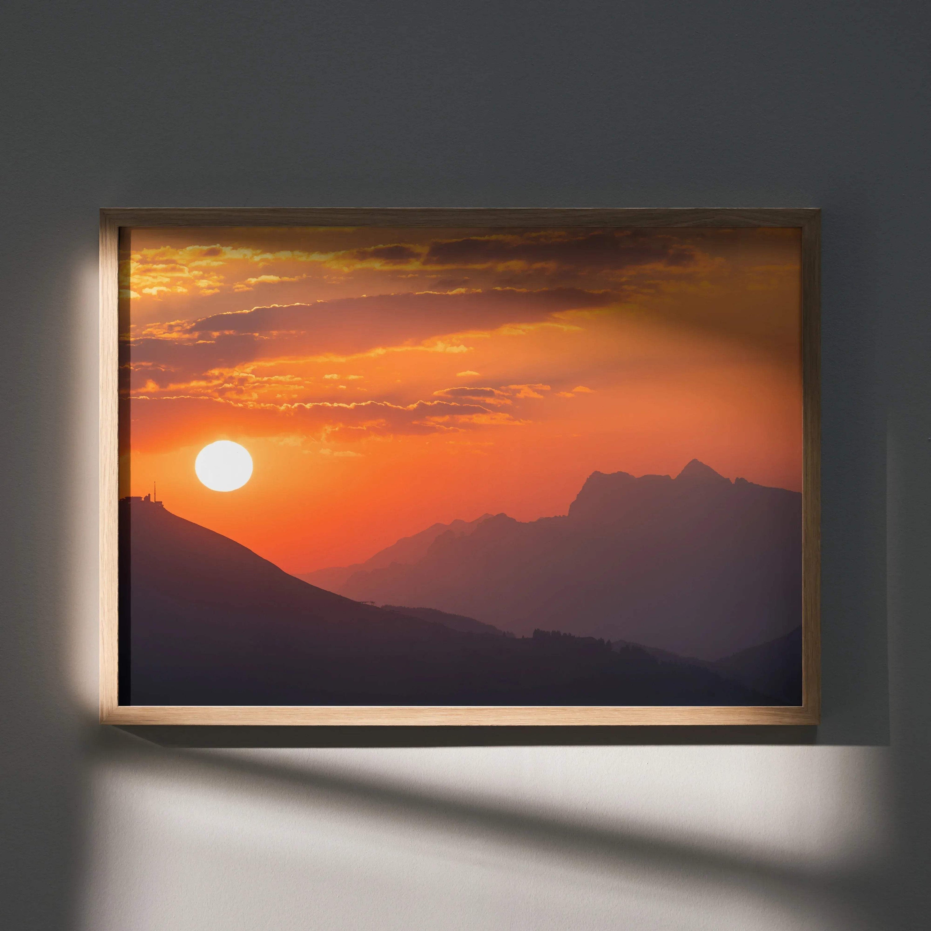 Majestic sunset over layered mountain silhouettes framed wall art poster with warm orange and purple tones.