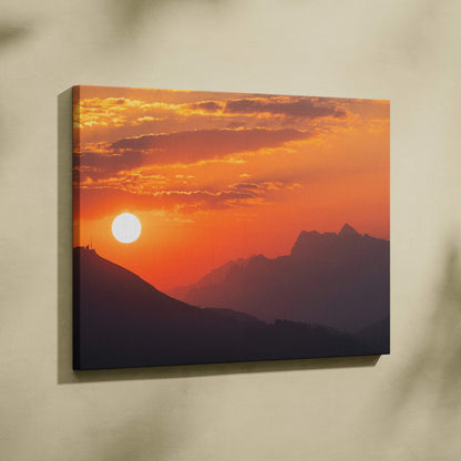 Majestic mountain sunset canvas wall art with vibrant orange sky and silhouetted peaks.