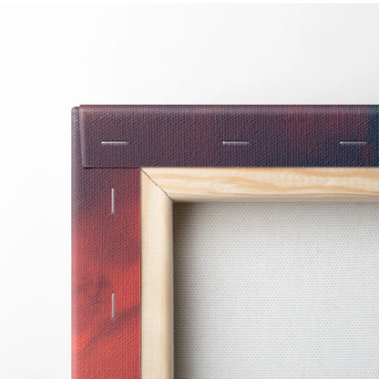 Close-up of wooden frame and stapled edge of canvas wall art with deep red tones on the back.