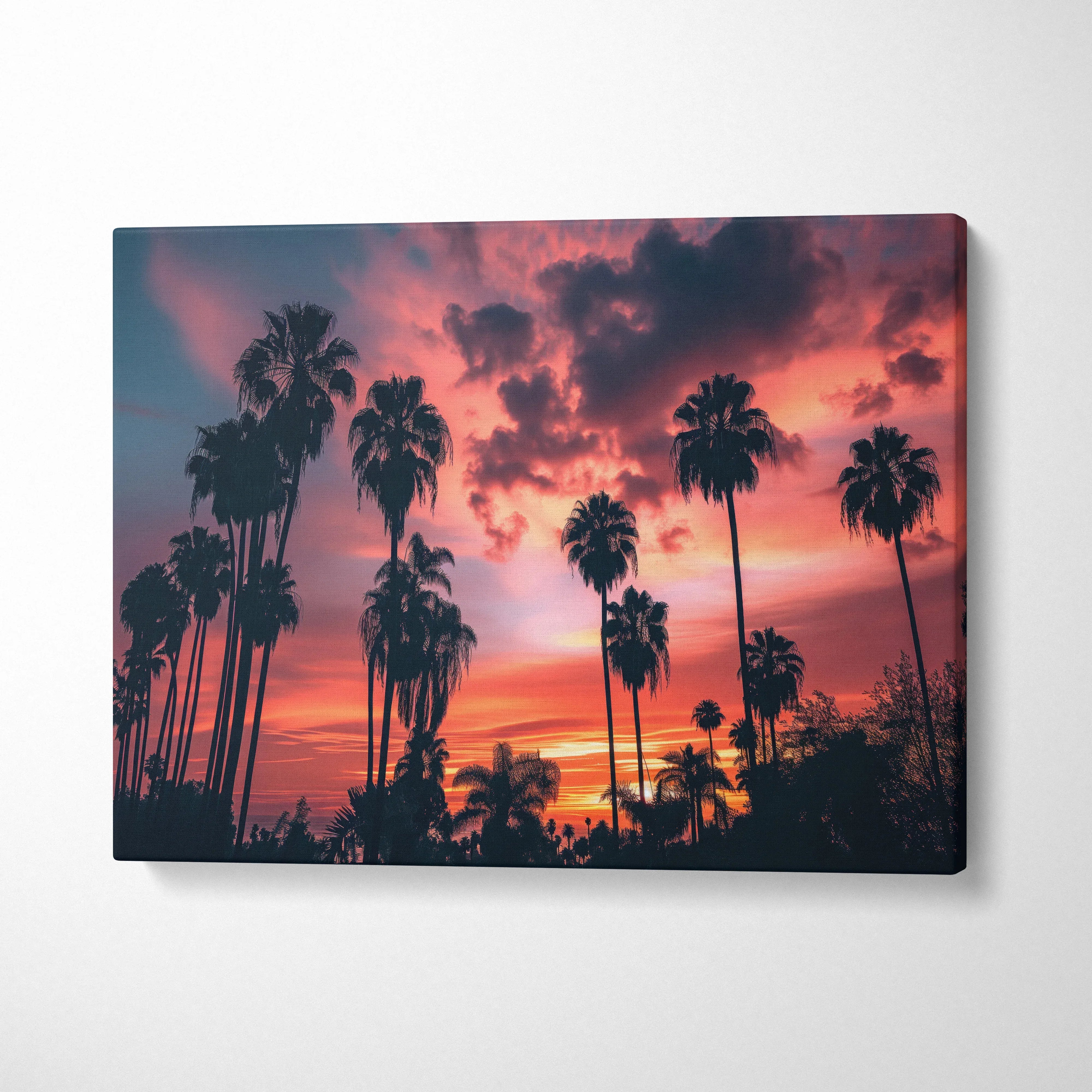 Canvas wall art featuring tropical palm trees silhouetted against a vibrant red and orange sunset sky for stylish decor.