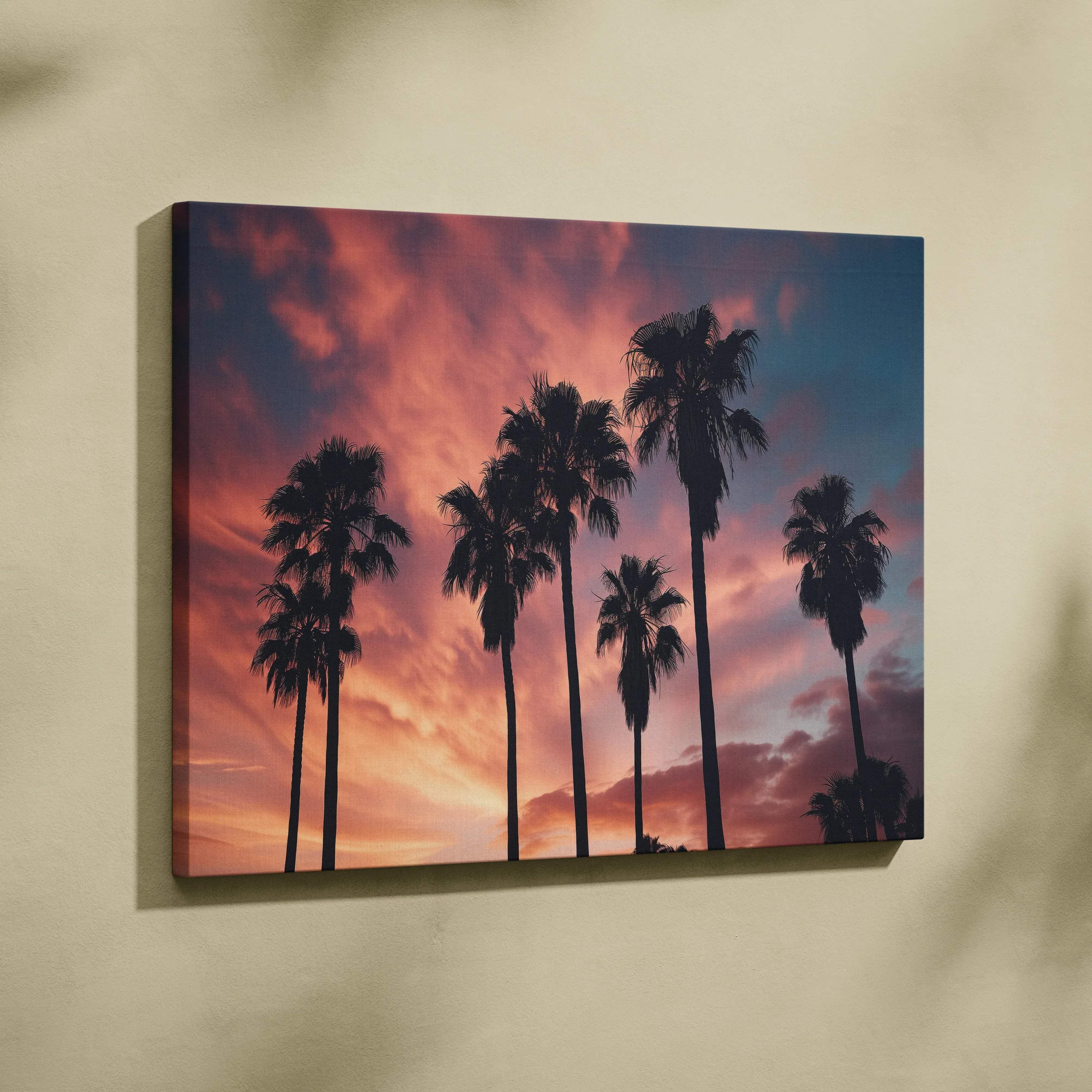 A rectangular canvas print featuring silhouetted palm trees against a vibrant pink orange and deep blue sunset sky for living room decor