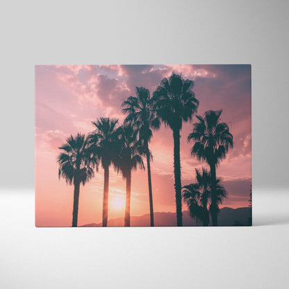 Canvas art featuring black palm tree silhouettes against a warm pink and orange sunset sky.