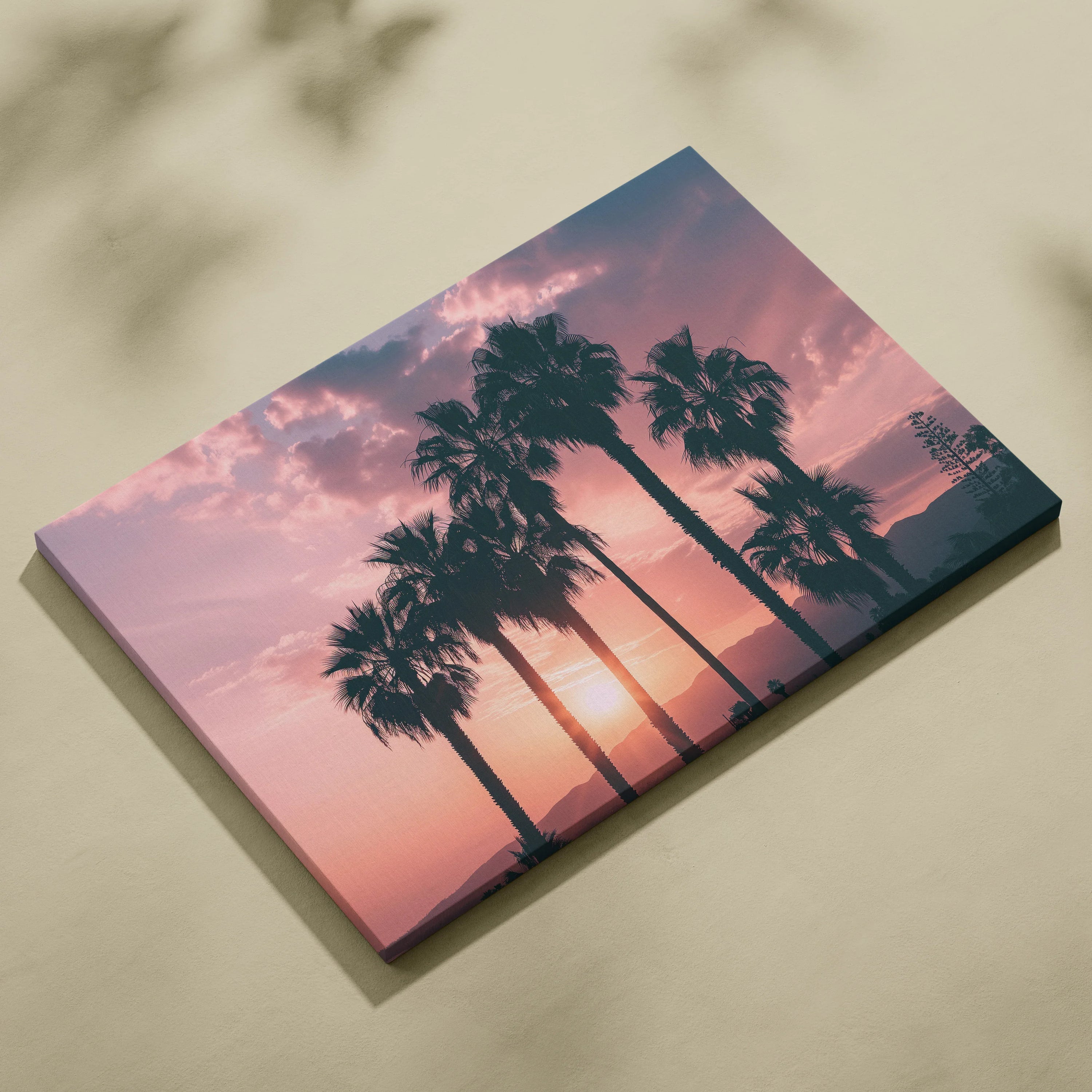 Canvas wall art featuring black palm tree silhouettes against a warm pink and orange sunset sky.